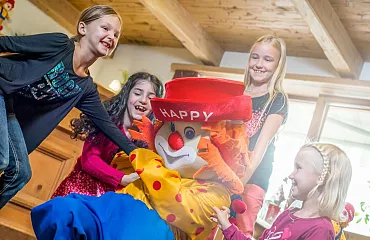 Kinder spielen und lachen mit Happy, dem lustigen Clown.
